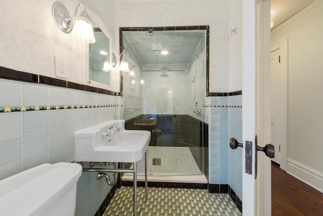 525 Main St, Owatonna, MN 55060 - bathroom featuring a wainscoted wall, toilet, a shower stall, tile walls, and a sink