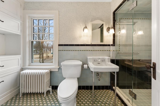 525 Main St, Owatonna, MN 55060 - bathroom with wallpapered walls, a stall shower, toilet, radiator heating unit, and wainscoting