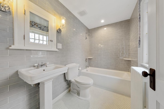 525 Main St, Owatonna, MN 55060 - bathroom with shower / bathtub combination, radiator heating unit, visible vents, toilet, and tile walls
