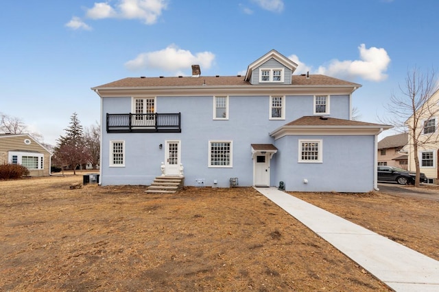 525 Main St, Owatonna, MN 55060 - back of property featuring a chimney, stucco siding, and a balcony