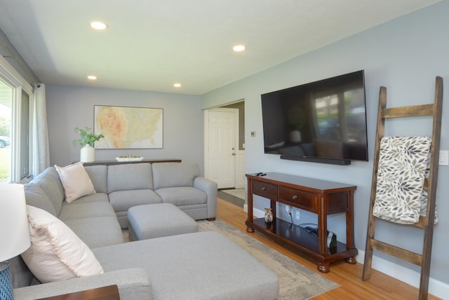 living area featuring light wood-style flooring, recessed lighting, and baseboards