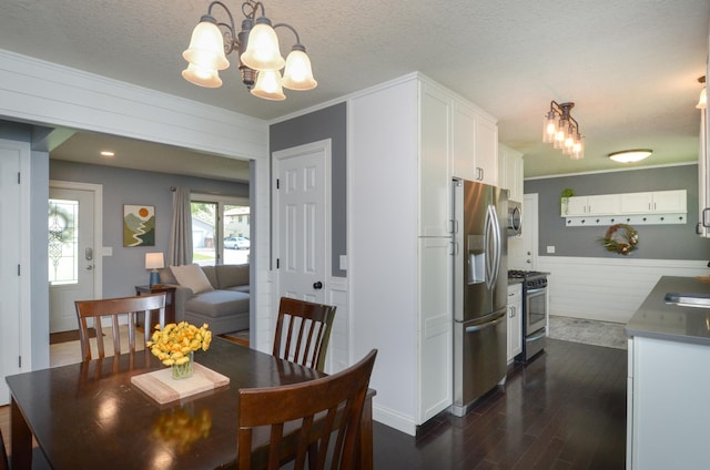 dining area featuring a chandelier, dark wood finished floors, crown molding, a textured ceiling, and baseboards