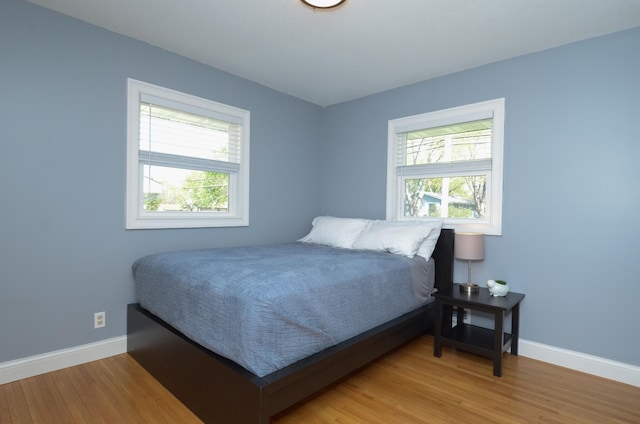 bedroom featuring baseboards and wood finished floors