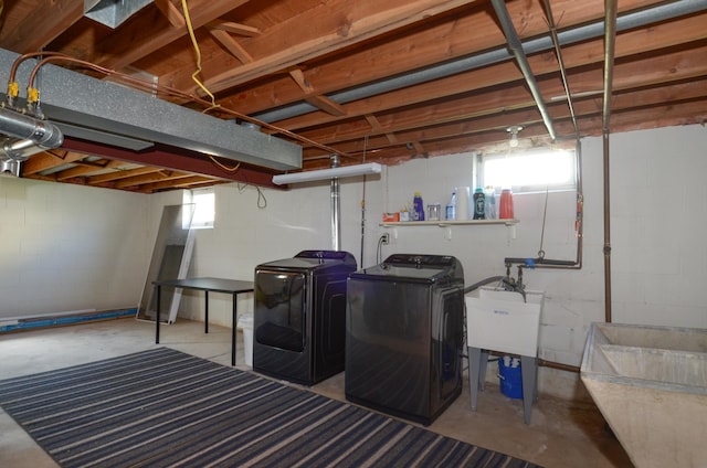 basement featuring separate washer and dryer and a sink