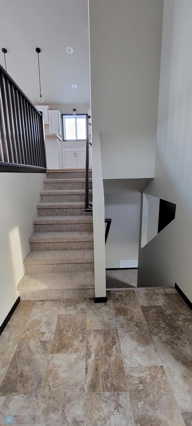 staircase with baseboards and stone finish flooring