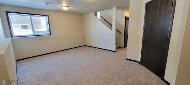 spare room with light colored carpet and baseboards