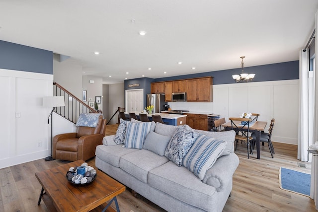 6921 Huckleberry Dr, Minnetrista, MN 55331 - living room with a chandelier, stairway, light wood-type flooring, a decorative wall, and recessed lighting