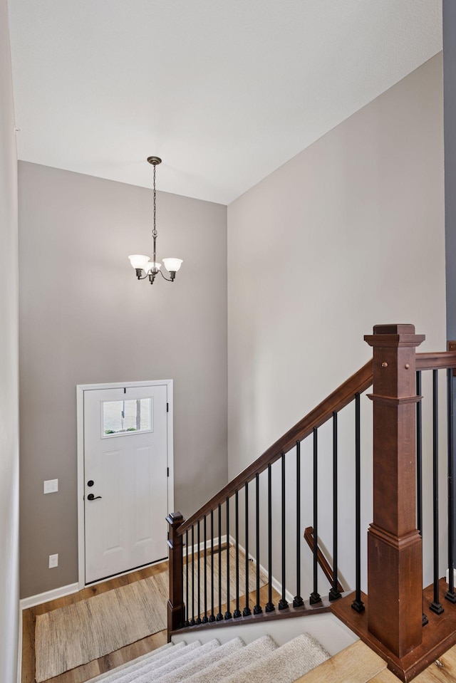 6921 Huckleberry Dr, Minnetrista, MN 55331 - entryway featuring wood finished floors, a chandelier, stairway, and a high ceiling