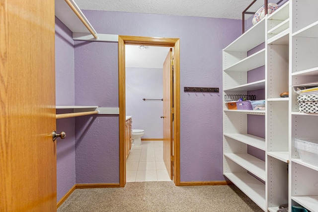 spacious closet featuring tile patterned floors and carpet