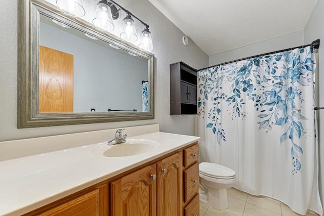 bathroom with toilet, a textured wall, vanity, and tile patterned floors