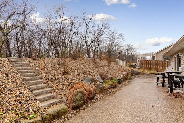 view of yard featuring fence and stairway