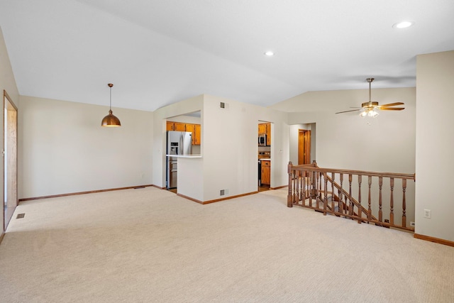 empty room featuring baseboards, visible vents, light carpet, and lofted ceiling