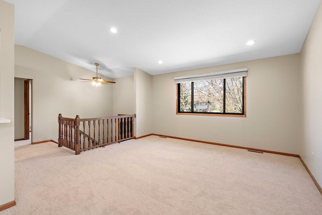 spare room featuring baseboards, vaulted ceiling, and light carpet