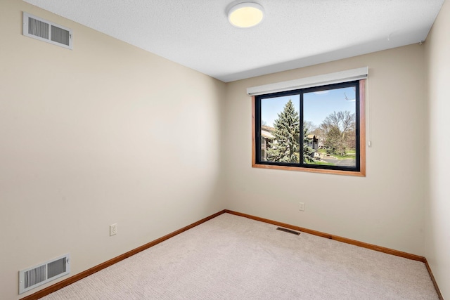 empty room featuring baseboards, visible vents, and carpet