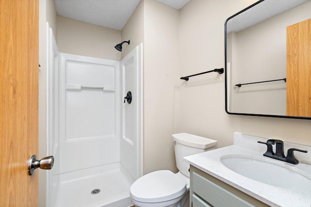 bathroom with vanity, toilet, and a shower stall