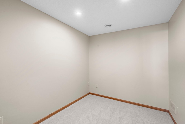 empty room featuring light colored carpet, recessed lighting, baseboards, and visible vents