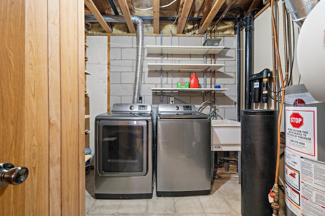 laundry area with separate washer and dryer, laundry area, a sink, and concrete block wall