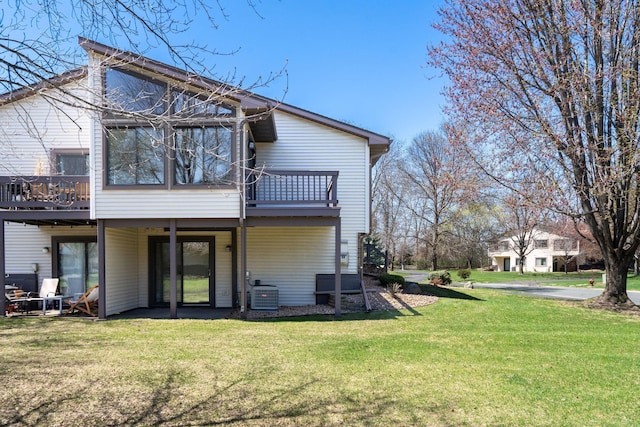 rear view of property with a yard, a deck, and cooling unit