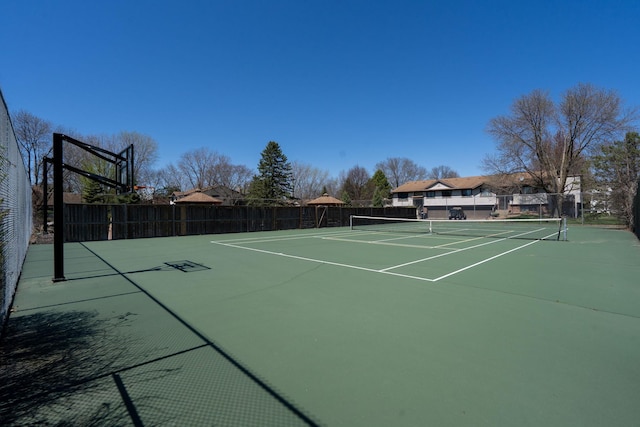view of tennis court featuring fence and community basketball court