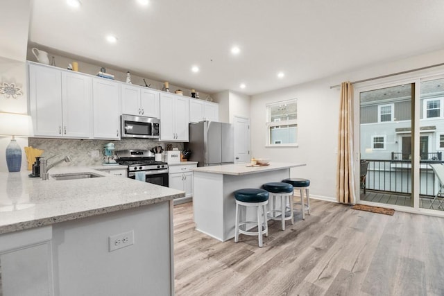775 Roselyn Dr, Victoria, MN 55386 - kitchen featuring stainless steel appliances, a sink, light wood-type flooring, and backsplash