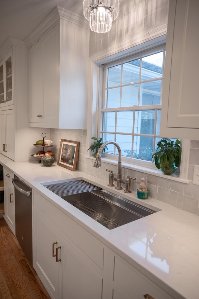 kitchen with a sink, white cabinets, and dishwasher