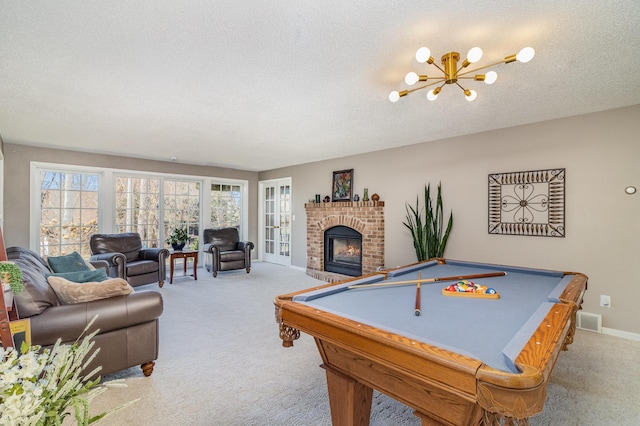 rec room featuring a fireplace, billiards, carpet, and a notable chandelier