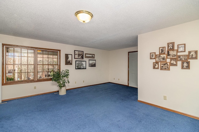 unfurnished room featuring carpet floors, a textured ceiling, and baseboards