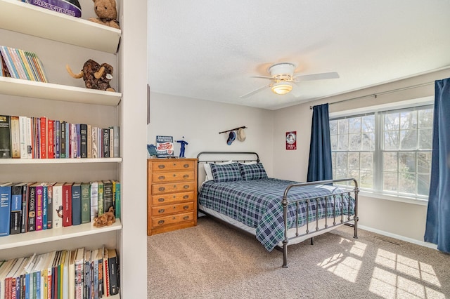 bedroom with baseboards, a ceiling fan, carpet flooring, and visible vents