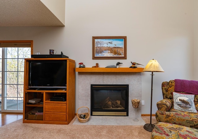 living area featuring carpet floors and a tiled fireplace