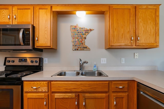 kitchen featuring a sink, brown cabinets, light countertops, and appliances with stainless steel finishes