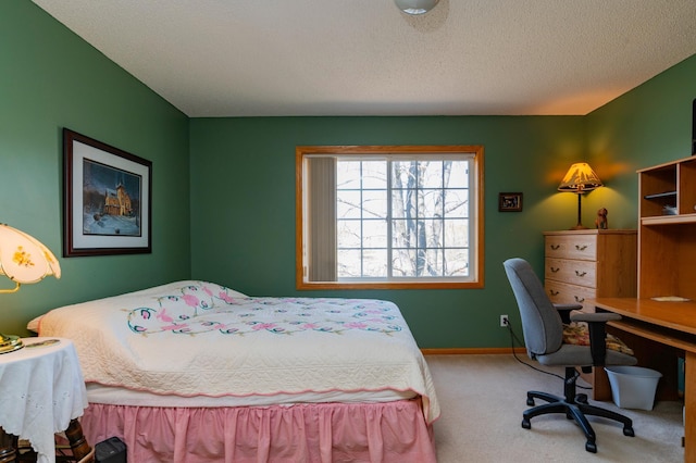 bedroom featuring baseboards, a textured ceiling, and carpet