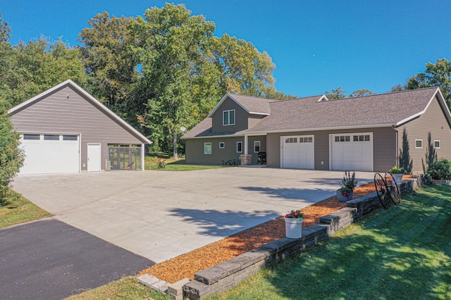 view of front facade featuring a shingled roof, driveway, and a front lawn