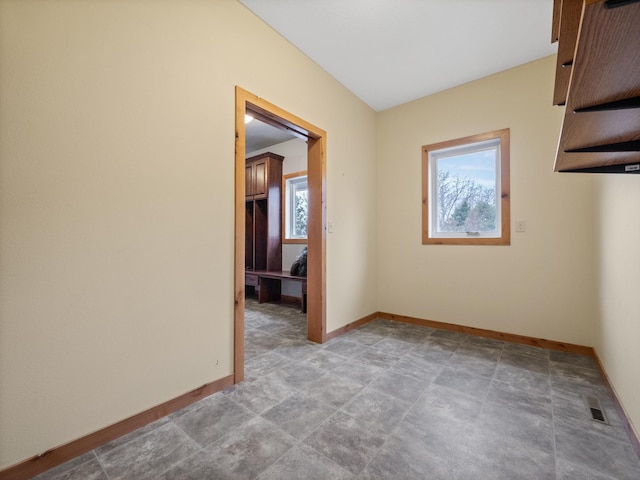 empty room with baseboards, visible vents, and a wealth of natural light