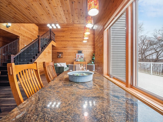 dining space with wood walls and stairs