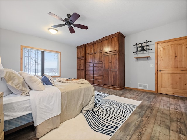 bedroom with baseboards, wood finished floors, visible vents, and ceiling fan