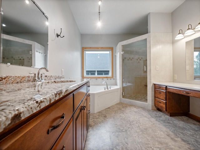 full bathroom with a shower stall, a garden tub, a sink, track lighting, and two vanities