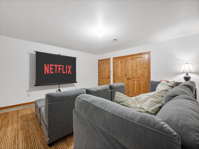 carpeted cinema room featuring baseboards and visible vents