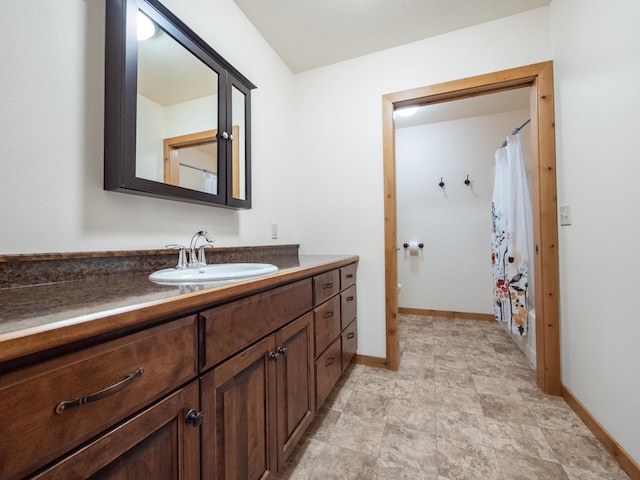 bathroom featuring baseboards, a shower with curtain, and vanity