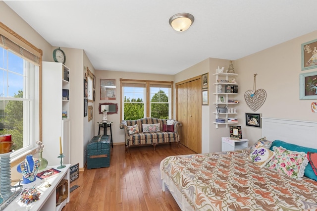 bedroom featuring light wood finished floors, a closet, and baseboards