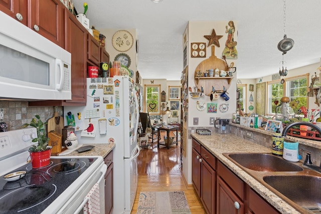 1920 Red Maple Ln, Northfield, MN 55057 - kitchen with white appliances, light wood finished floors, tasteful backsplash, pendant lighting, and light stone counters