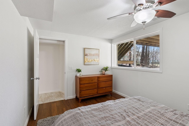bedroom featuring wood finished floors, a ceiling fan, and baseboards