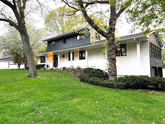 view of front of property featuring brick siding and a front yard