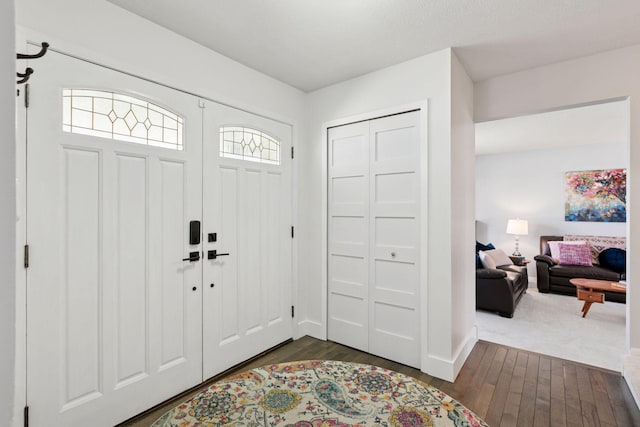entryway featuring baseboards and dark wood-style flooring