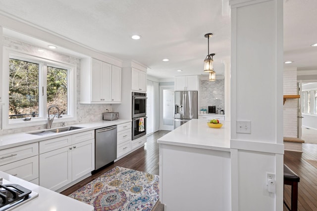 kitchen featuring white cabinets, stainless steel appliances, a sink, and tasteful backsplash