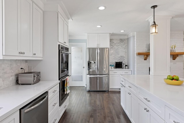 kitchen featuring white cabinets, dark wood finished floors, light countertops, tasteful backsplash, and appliances with stainless steel finishes