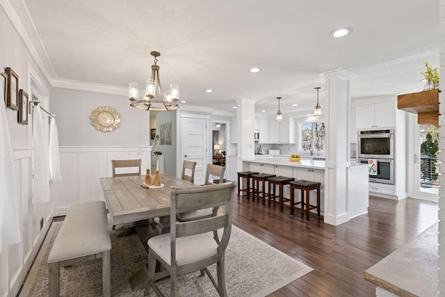dining space with recessed lighting, a wainscoted wall, ornamental molding, a decorative wall, and dark wood-style flooring
