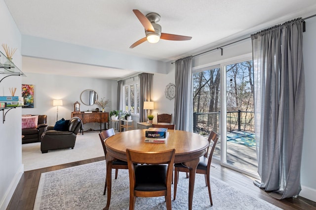 dining room featuring baseboards, wood finished floors, and ceiling fan