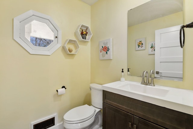 bathroom with visible vents, vanity, and toilet
