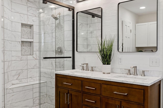 bathroom featuring double vanity, tile walls, a stall shower, and a sink