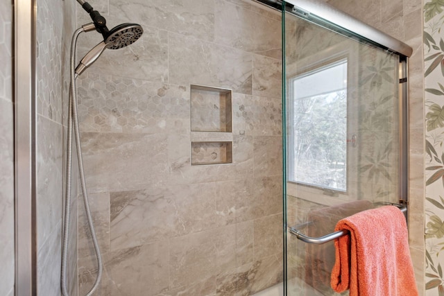 bathroom with a healthy amount of sunlight and tiled shower